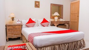 A neatly arranged bedroom with a bed, bedside tables, a dresser, a mirror, and a wardrobe. - Standard Double near Pantai Padang (Padang)