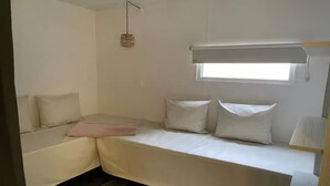 A compact room with a bed, a small window, and a hanging light fixture. - Cozy Coco Sweet Glamping Tent for 4 (Rijkevorsel)