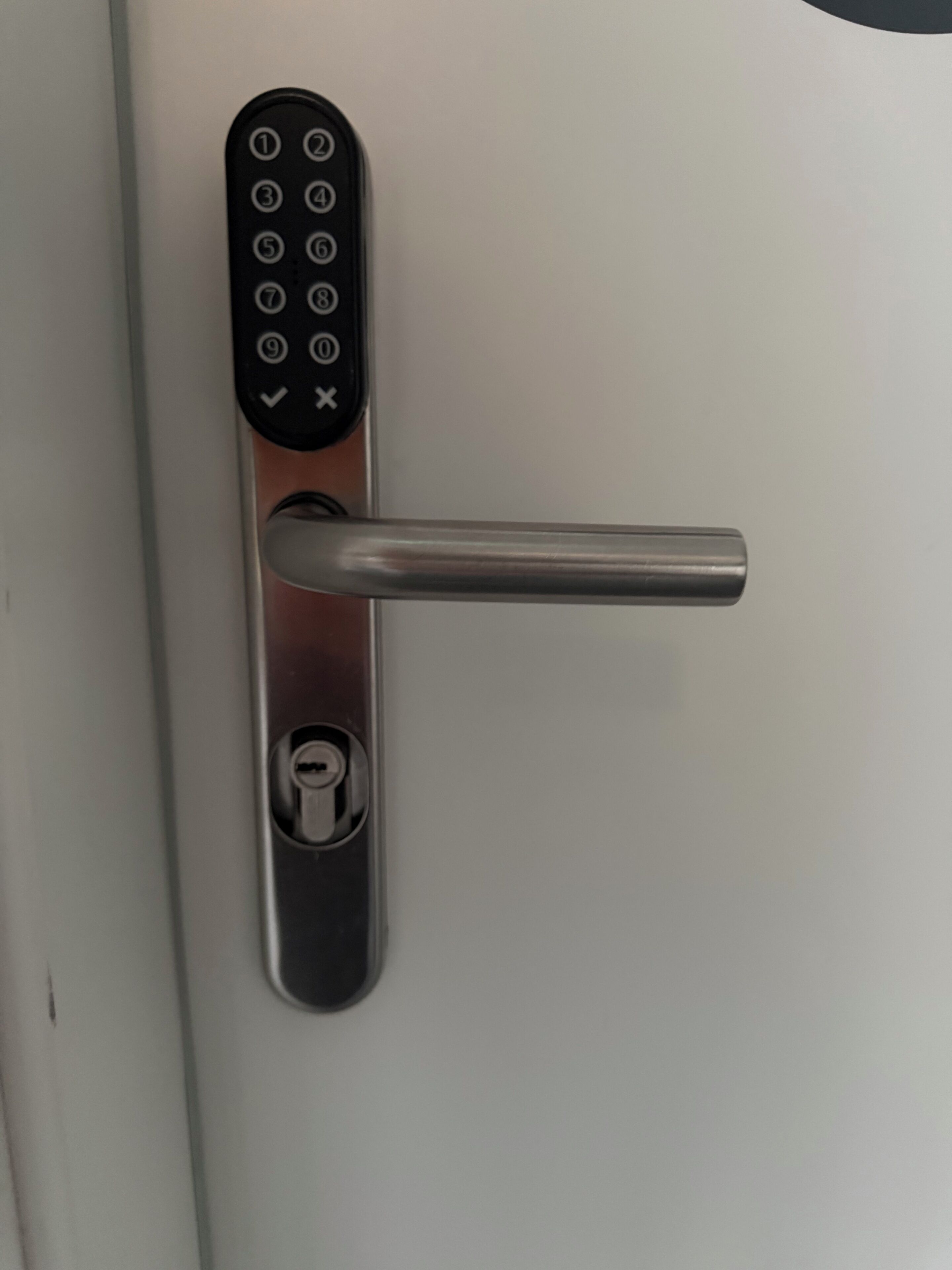 Une porte dotée d’un système de verrouillage moderne à clavier numérique et d’un trou de serrure.