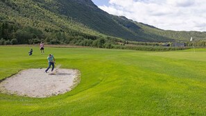 A golf course with a putting green, a sand bunker, and a mountainous backdrop. - Mountain gem-  Ski in/out & panorama views (Hemsedal)