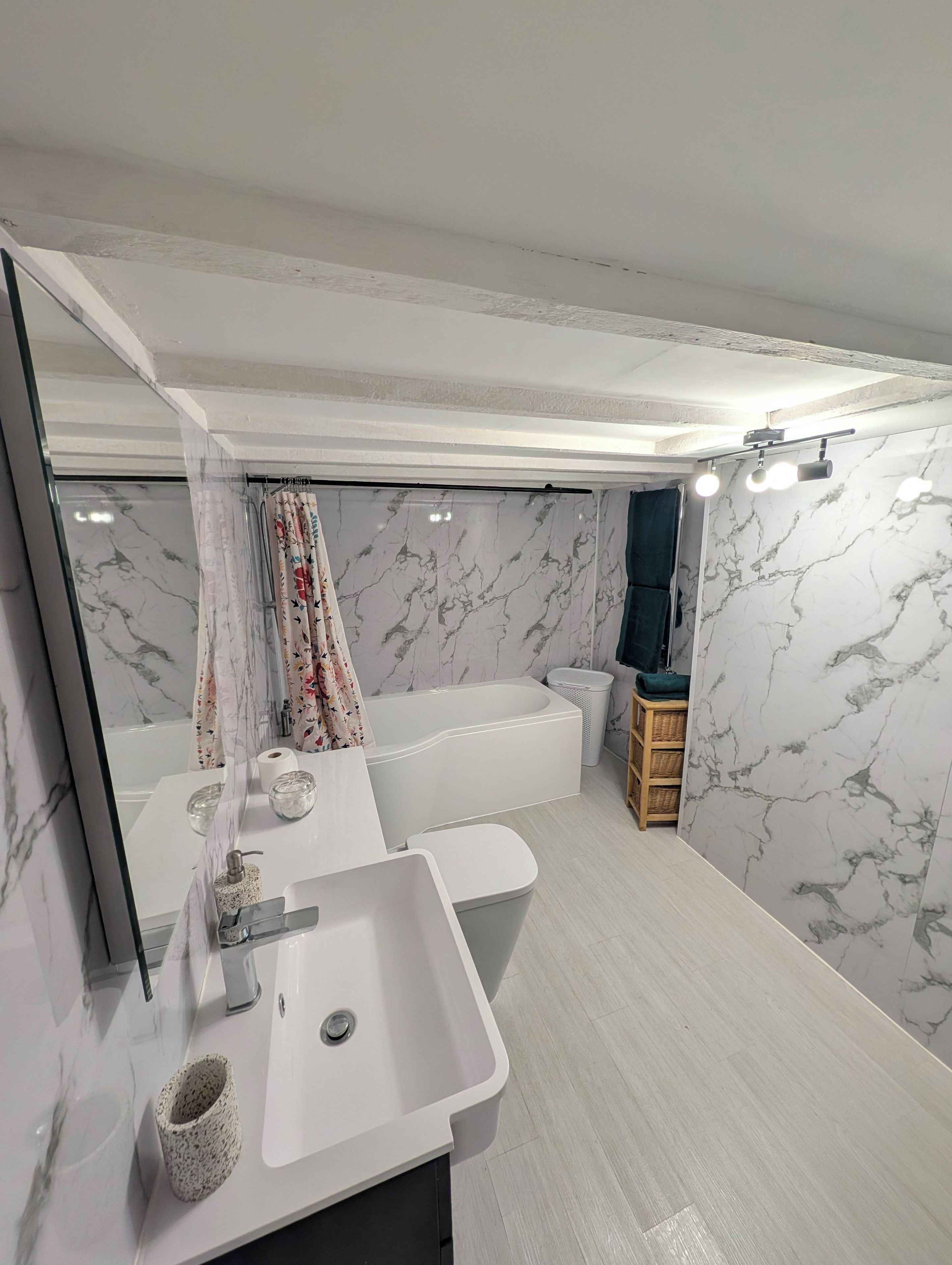 Un baño moderno con un lavamanos grande, una bañera y una zona de ducha.