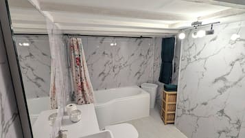 Un baño moderno con un lavamanos grande, una bañera y una zona de ducha.