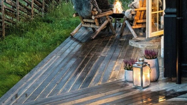 A wooden deck with two chairs and a small fire pit, overlooking a forested landscape. - Cabin in Uvdal with ski trails on the doorstep (UVDAL)