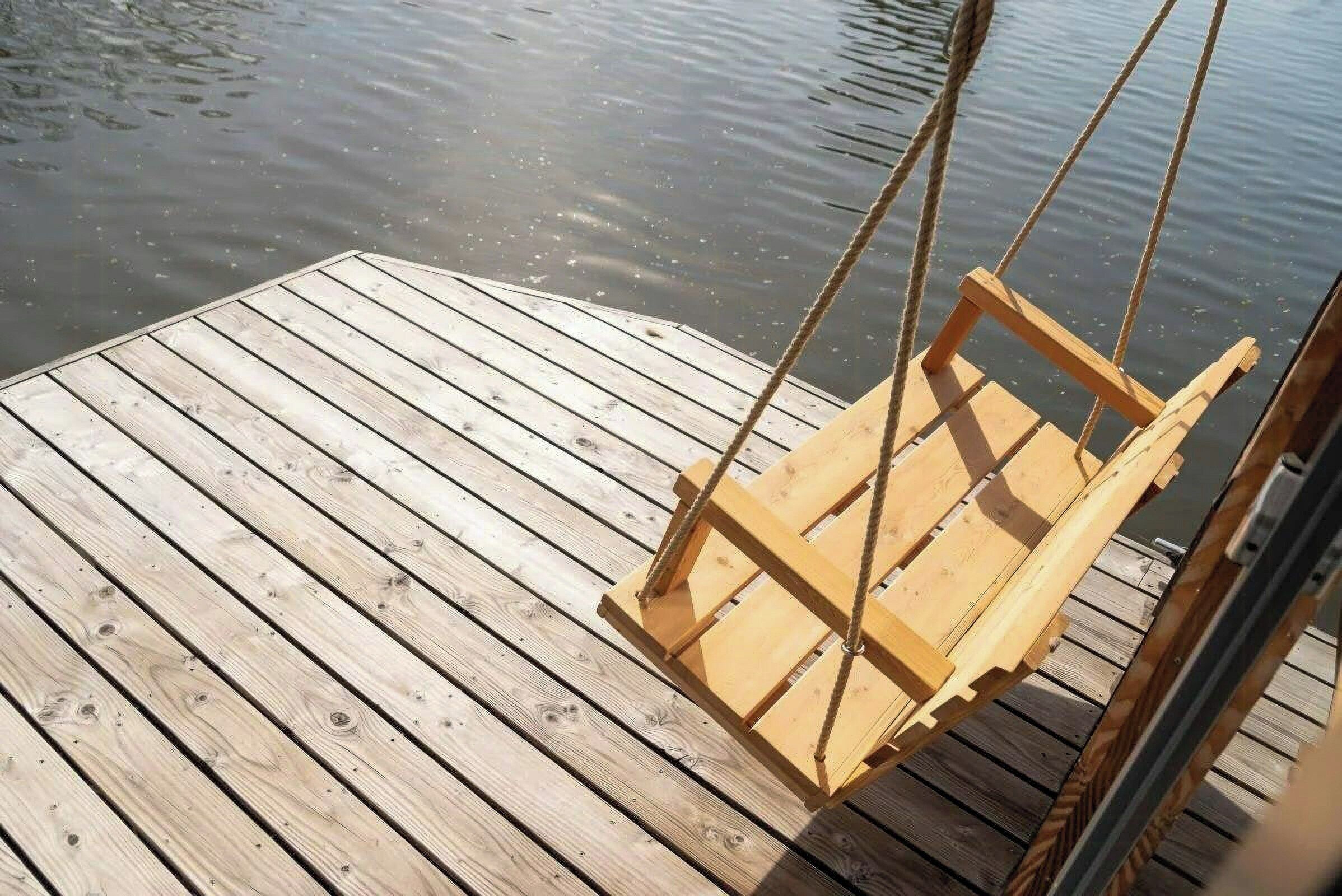 Un molo di legno con una sedia a dondolo.
