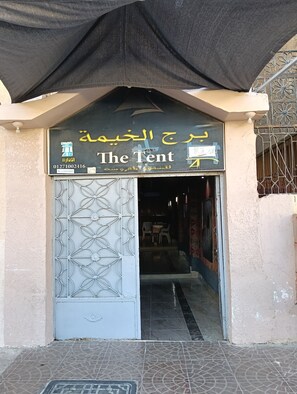 A building entrance with a sign reading 'The Tent' and Arabic text above it. - The Tent (Marsa Matrouh)