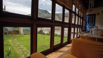 A room with large windows, a wooden floor, and a yellow chair.