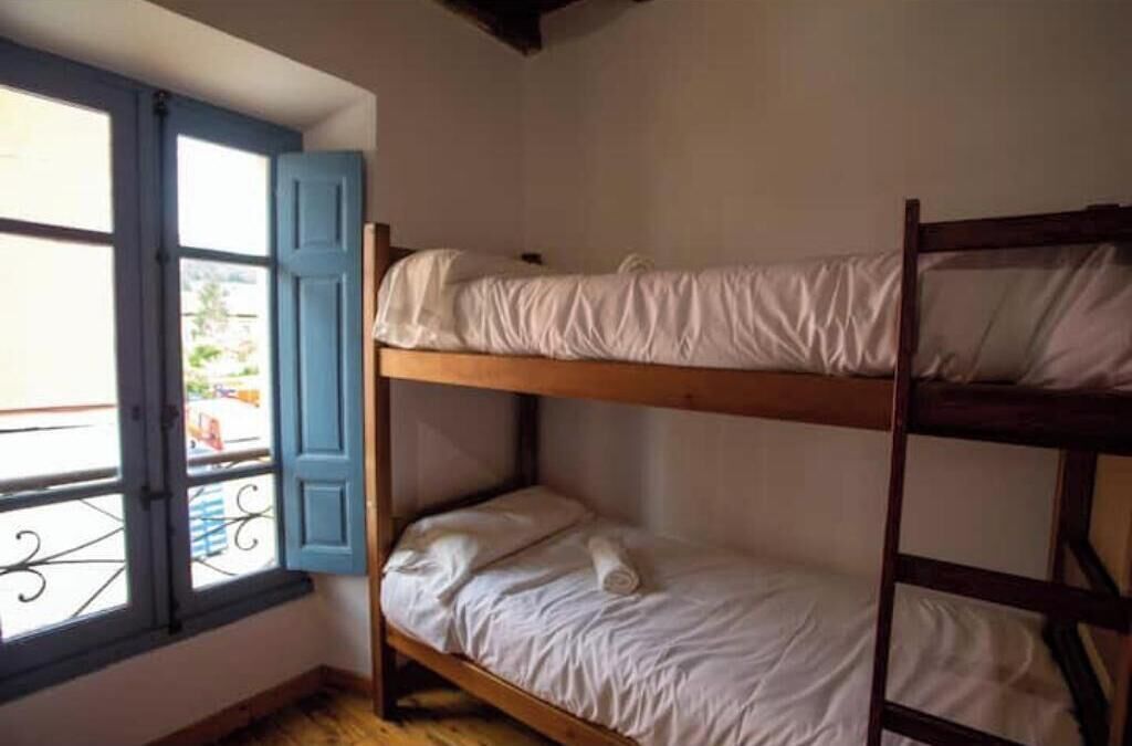 A bunk bed room with a window and a balcony.