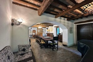 A dining area with a long table, chairs, and a chandelier. There is a wooden ceiling and a door in the background. - Peaceful Country Retreat near Pesaro (Pesaro)