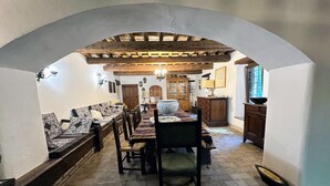 Un espace repas doté d’un sol en pierre, de meubles en bois et d’un plafond en arc de cercle.