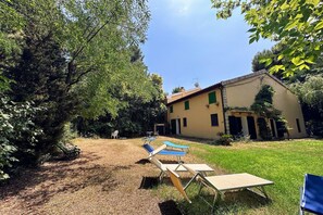 A building with a garden, outdoor furniture, and a clear sky. - Peaceful Country Retreat near Pesaro (Pesaro)