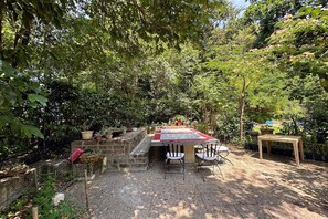 A garden patio with a table and chairs, surrounded by potted plants and trees. - Peaceful Country Retreat near Pesaro (Pesaro)
