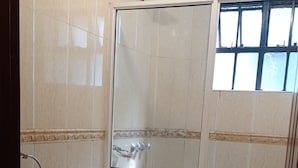 Un baño con inodoro, bidé y ducha.