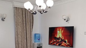 Sala de estar con sofá, mesa de centro, televisor y dispensador de agua.