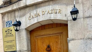 Ein Steinhaus mit einer Holztür, auf der 'CASA D'AZUR' steht.