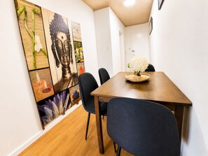 A dining area with a wooden table, black chairs, and a Buddha painting on the wall. - 3BDR Apt in the Heart of Strathfield (Strathfield)