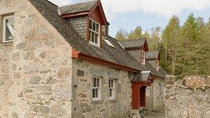 A stone building with multiple windows and a sloped roof. - Cosy, newly renovated five bedroom cottage in the Highlands. Pet friendly! (Moy)