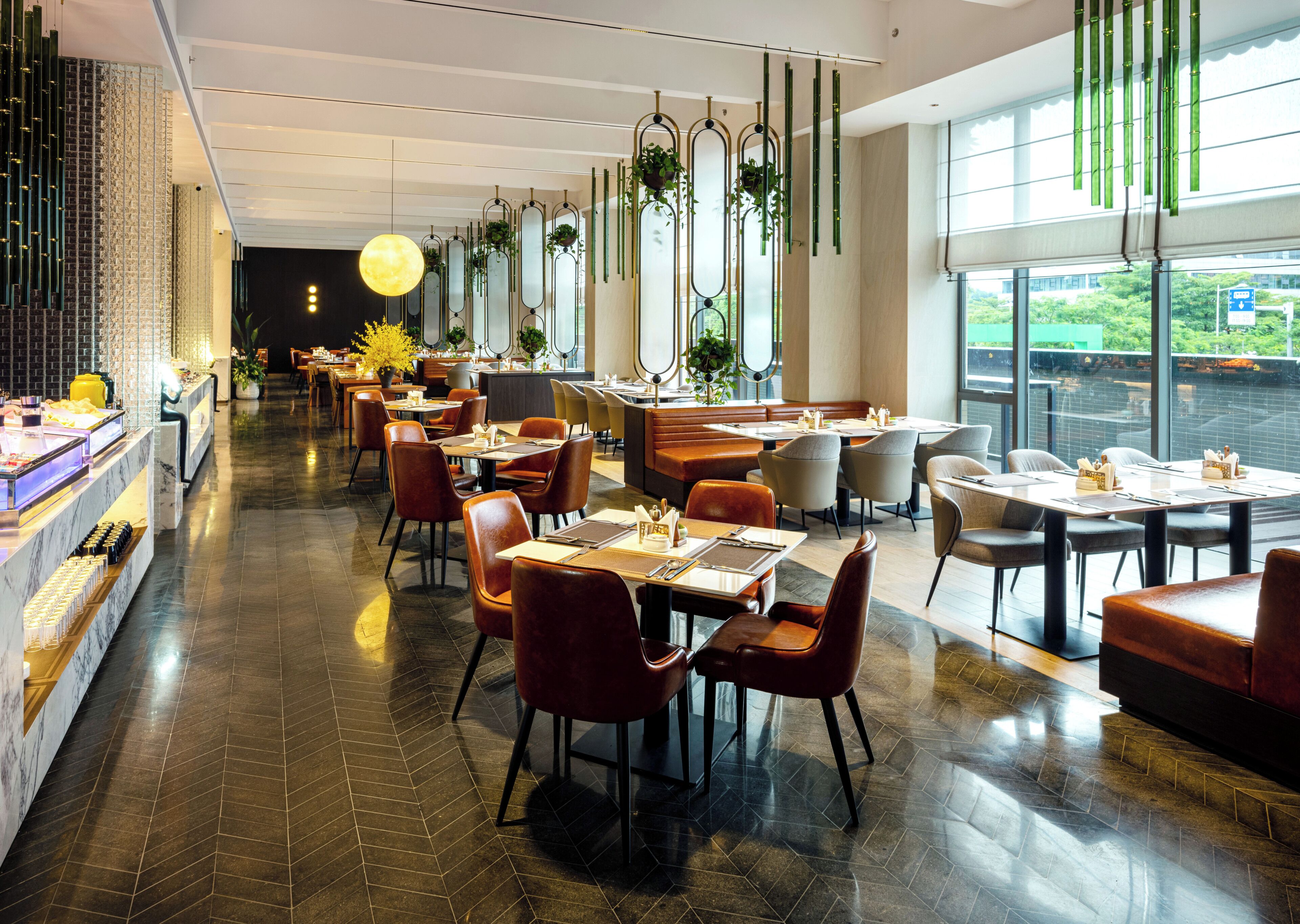 A modern restaurant with a long counter, multiple seating areas, and large windows.