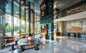 Um lobby moderno com lareira, área de estar e espaço para café.
