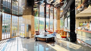 Un hall espacioso con grandes ventanales, una zona de estar central y un diseño moderno.