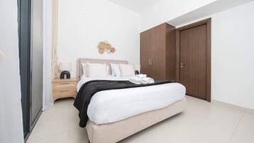 Een slaapkamer met een bed, nachtkastje en kledingkast.