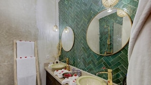 Casa de banho com duas pias, um espelho e um porta-toalhas.
