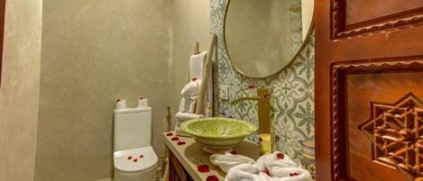 A bathroom with a toilet, sink, and mirror.