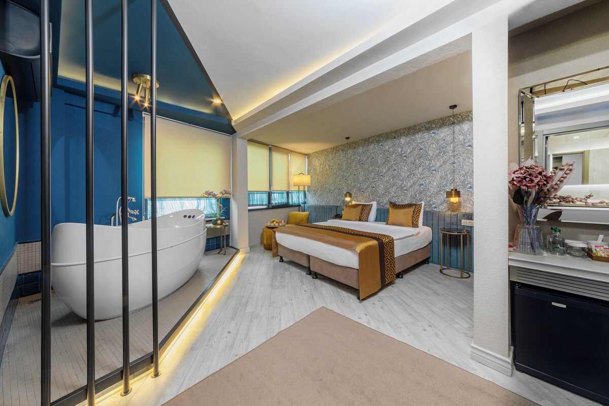 Ein modernes Schlafzimmer mit einem großen Bett, einer Badewanne und einem separaten Badebereich.