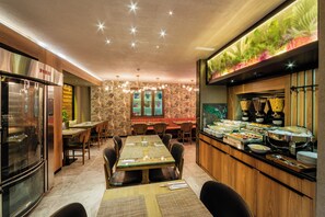 Ein Restaurant mit Buffet, Holztischen und einem großen Aquarium.