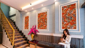 A hotel lobby with a staircase, a reception desk, and two large tropical-themed paintings on the wall. - Bond Hotel Istanbul (Istanbul)