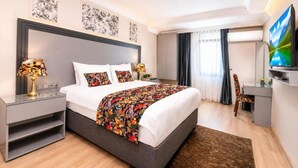 A modern hotel room with a large bed, bedside tables, a flat-screen TV, and artwork on the walls. - Bond Hotel Istanbul (Istanbul)