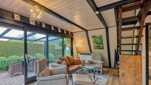 A modern interior with a glass ceiling, leather furniture, and a view of the garden.