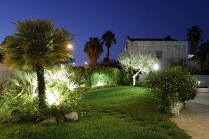 A well-maintained garden with various plants and a pathway leading to a building. - Path House - Standard Etna 2 by Wonderful Italy (Riposto)
