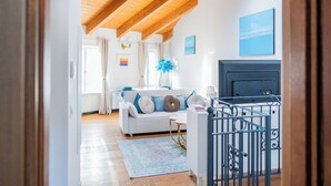 A room with a white sofa, a blue rug, a fireplace, and a skylight. - Côte d'Azur Penthouse | 45 m² in Downtown Cannes (Cannes)