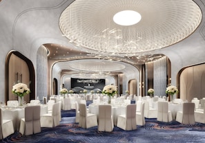 A banquet hall with round tables, white chairs, and floral centerpieces. - InterContinental Penang Resort by IHG (George Town)
