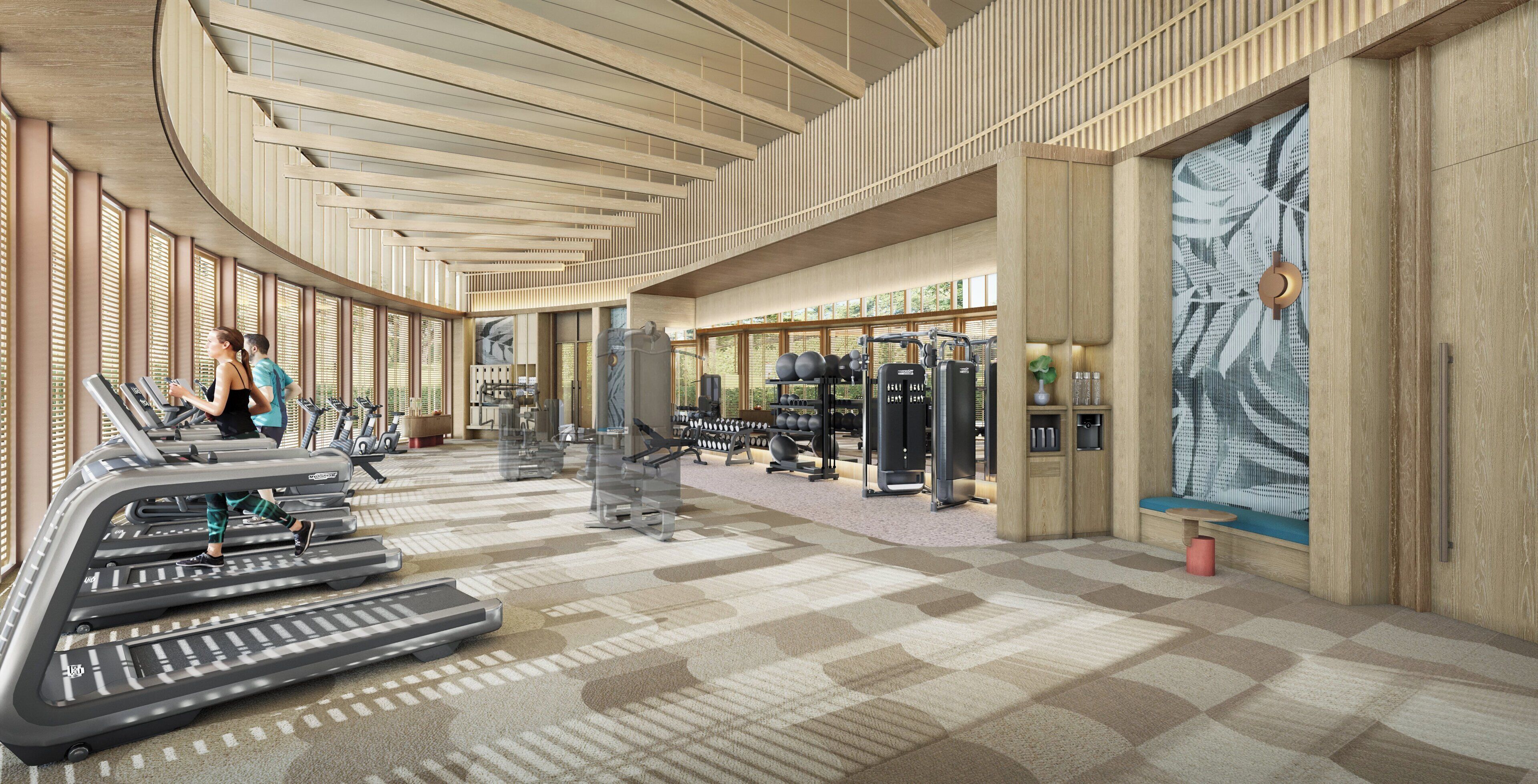 A gym with treadmills, weight machines, and a large window with a plant.