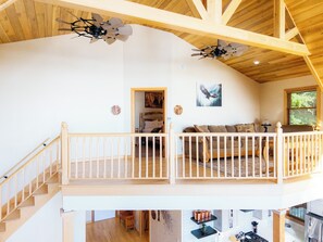 Un loft spacieux doté d’un balcon, de poutres apparentes et d’un plafond haut.