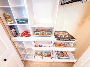 A game shelf with various board games. - 4BR Luxury Cabin | Hot Tub, Views & 3 King Master Suites (Bryson City)