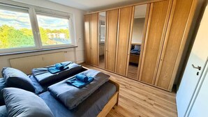 A bedroom with a bed, a wardrobe, and a window. - Apartment da Roberto - 3 (Langenhagen)