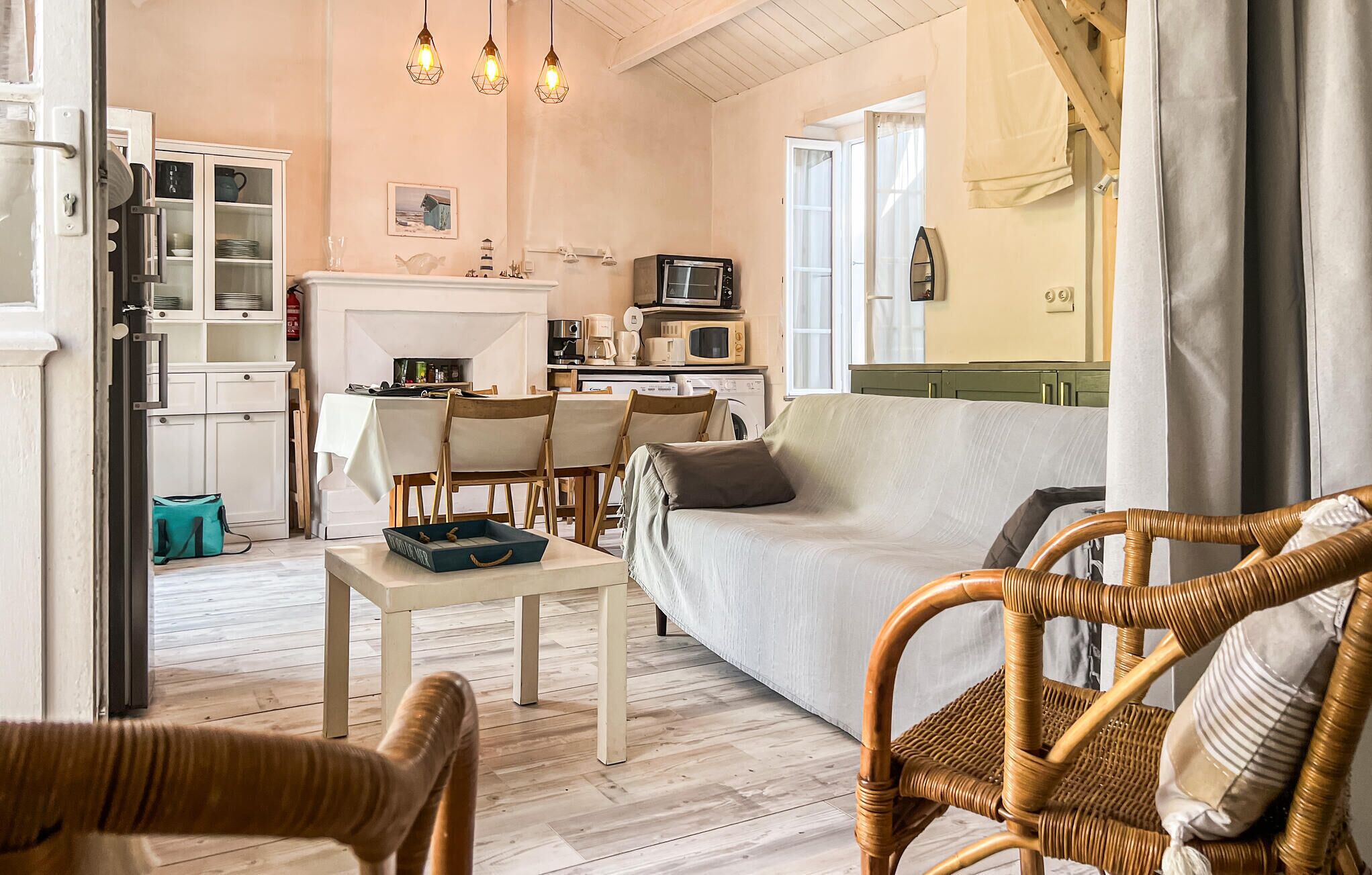 Een gezellige woonkamer met een bank, stoelen, een eettafel en een keuken met inbouwapparatuur.