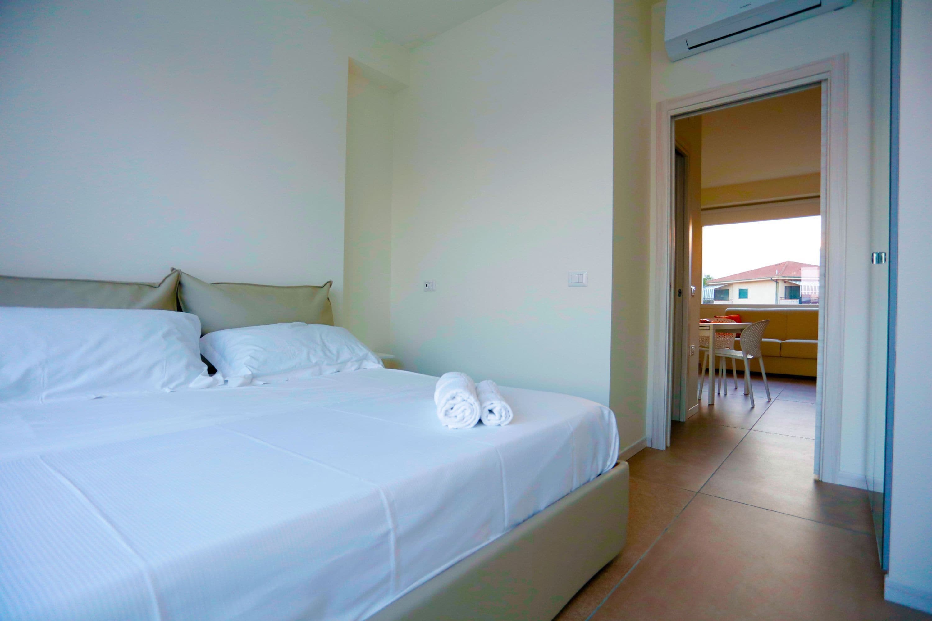 Una camera d'albergo con un letto, una sedia e un tavolo.