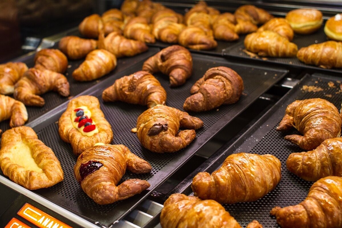 A bakery display with various types of croissants and pastries.