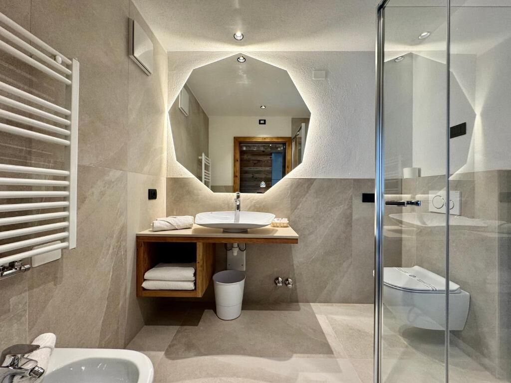 A modern bathroom with a freestanding bathtub, a large mirror, and a glass shower enclosure.