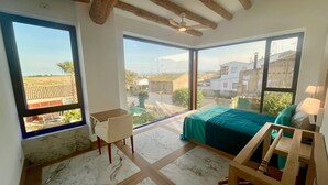 A bedroom with a large window, a bed, a desk, and a chair. - Chicos de Lastanosa 4 (Lastanosa)