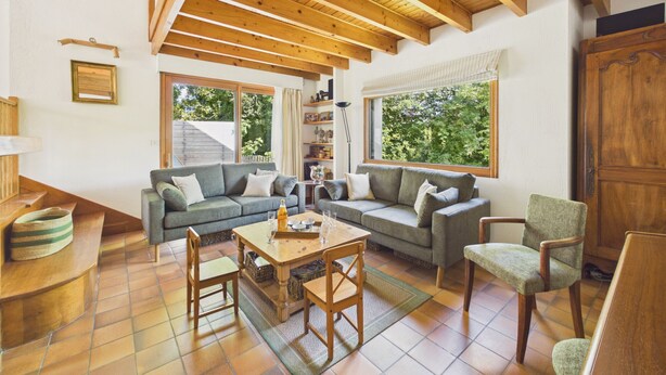 A cozy living room with a wooden ceiling, a grey sofa, a wooden coffee table, and a chair. - House for 8, fenced garden, terrace & BBQ (Fouesnant)