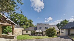 A residential property with a stone facade, a covered patio, and a gravel driveway. - House for 8, fenced garden, terrace & BBQ (Fouesnant)