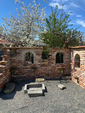 A brick structure with arched windows and a stone bench. - Brückelsee Chalet – Modern Holiday Home at Lake Brückelsee / Bavaria (Wackersdorf)