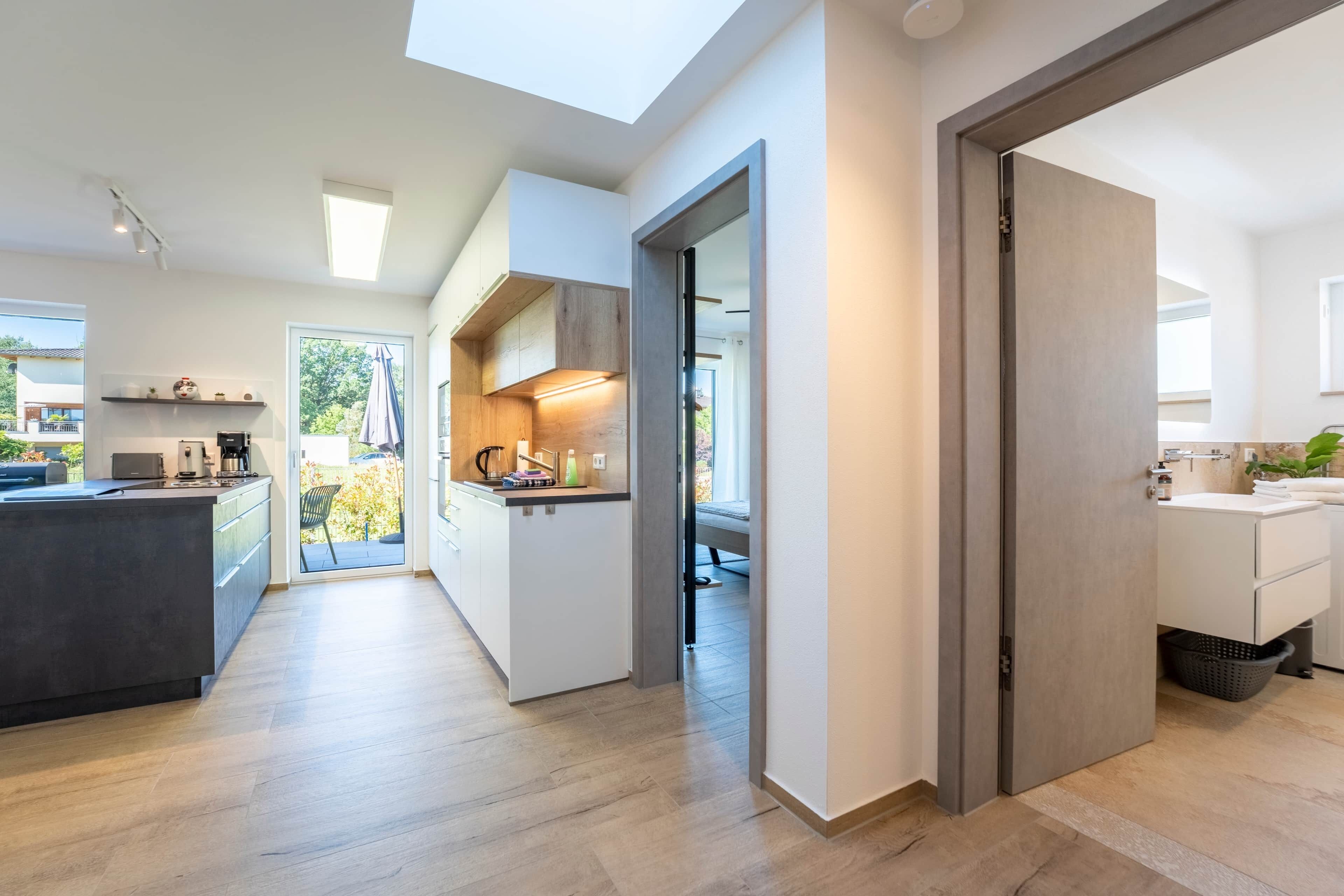 Een moderne keuken met een centraal eiland, een eethoek met uitzicht en een aparte badkamer.