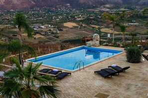A swimming pool with lounge chairs and a view of a valley. - Villa in Sicily with private pool (Castellammare del Golfo)