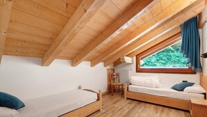 Un dormitorio con dos camas de madera, una ventana con cortinas y un radiador.