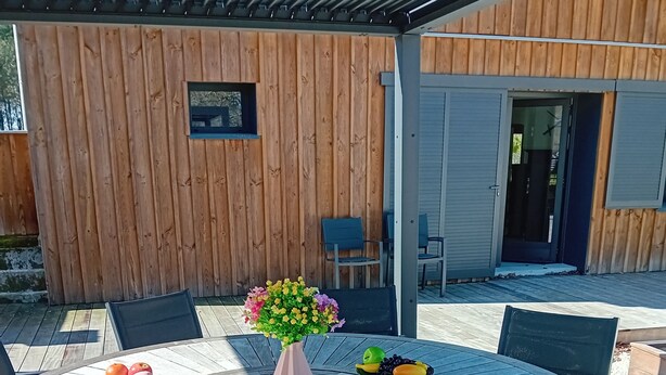 A round wooden table with chairs, a vase of flowers, and a fruit bowl. - Villa Nature Pool Air Cooler 12P (Sainte-Eulalie-en-Born)